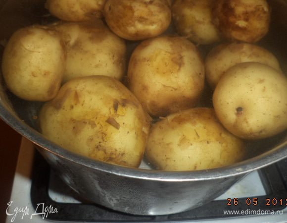 Картофель тщательно вымыть. Не очищая, варить  в подсоленной воде около 15-20 минут, до мягкости. Воду слить, картофель слегка остудить. 