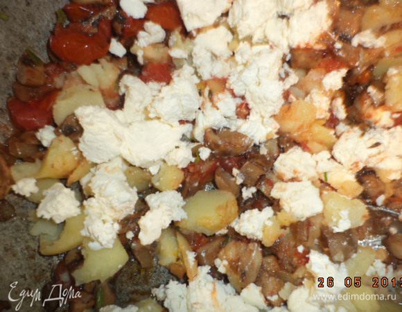 К грибам прибавить выбранную мякоть картофеля и 200 г феты. Тщательно перемешать.