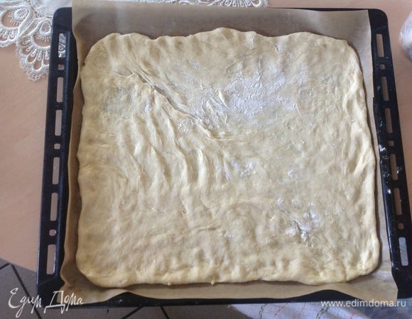 Тесто (половину от подошедшего) распределить на пергаментной бумаге, довольно тонко. Я это делаю пальцами, как для пиццы.