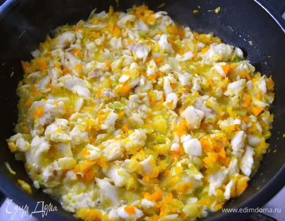 Положить рыбу к овощам. Перемешать и позволить рыбе слегка обжариться. Она приобретет светлый матовый цвет.