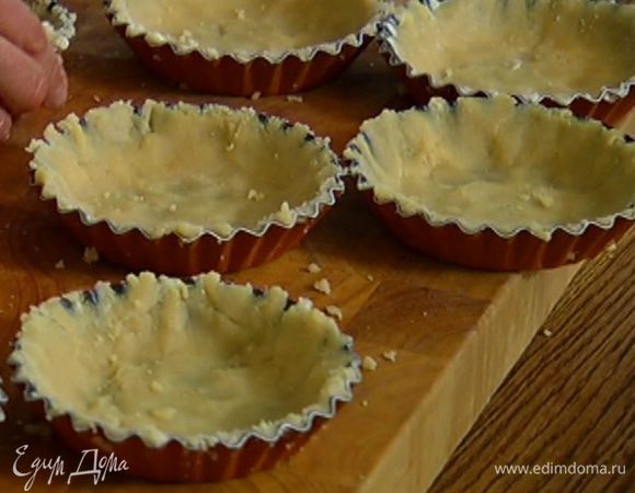 Формы для тарталеток смазать оставшимся сливочным маслом, равномерно распределить в них тесто так, чтобы получились бортики, и поместить в морозильник на 10 минут.