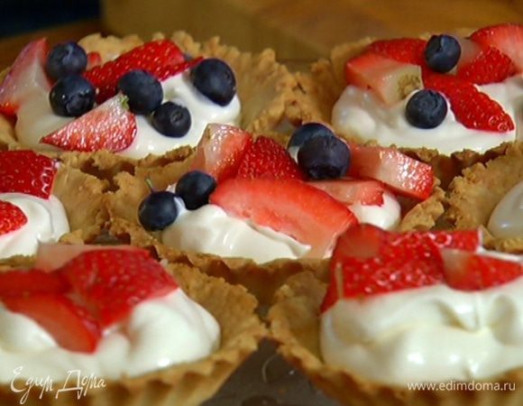 Готовые тарталетки остудить, наполнить взбитыми сливками, украсить ягодами и посыпать сахарной пудрой.