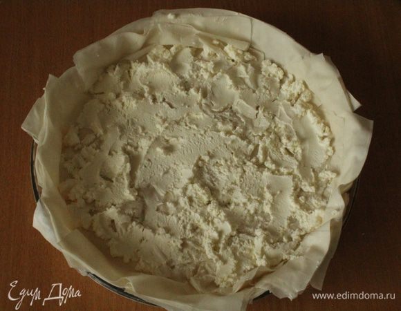 Выстелить смазанную оливковым маслом  форму для запекания листьями фило внахлест... Ровным слоем выложить сыр и равномерно его распределить на тесте.