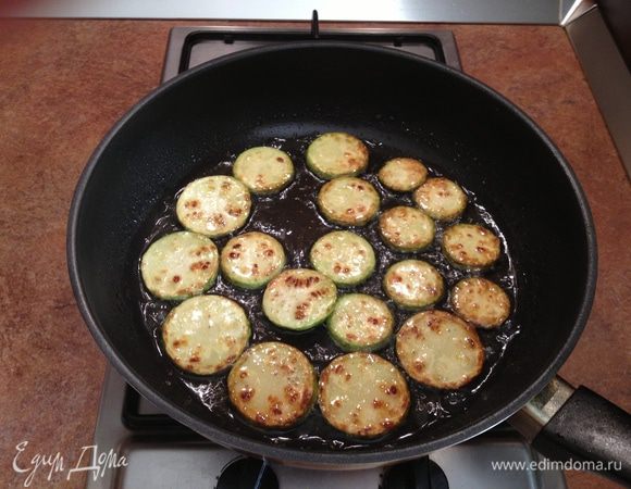 Кабачки нарезать кружочками, обжарить на подсолнечном масле, выложить на блюдо, на котором будете подавать.