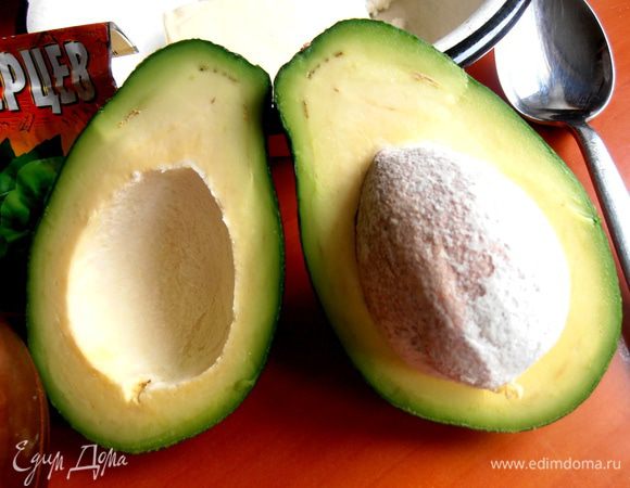 Авокадо разрезаем и вынимаем мякоть из одной половинки...