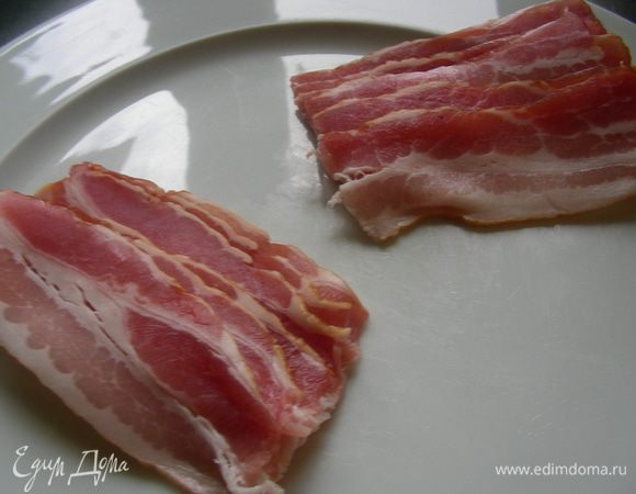 Деревянные палочки замачиваем в холодной воде минут на 30, чтобы они не пригорали. Если чернослив суховат, то можно его оставить в кипятке минут на 5 (затем воду сливаем и обсушиваем). Полоски бекона разрезаем пополам.
