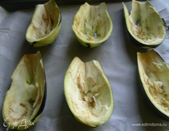 Баклажаны разрезаем напополам и вынимаем мякоть. В рецепте предлагается запечь чашечки сразу с начинкой, но мне надо, чтобы они как следует проготовились, поэтому я их немного смазала оливковым маслом и поставила в духовку 200 гр. на 20 минут. Чтобы они не высохли, можно их накрыть фольгой или запекать в ней. Этот шаг необязательный. 
