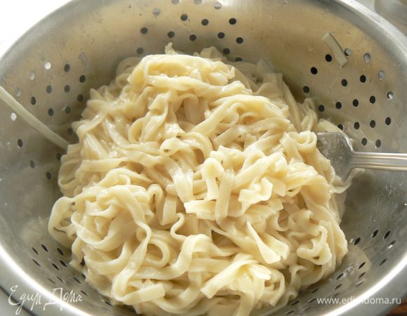 Отварить лапшу в подсоленной воде, откинуть на дуршлаг. 