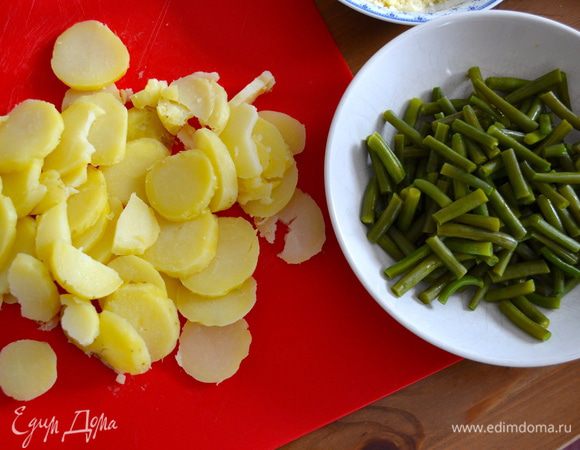 Картофель отварить в "мундире", очистить и нарезать кружочками. Фасоль также отварить примерно 10 минут в кипящей воде. Нарезать некрупными брусочками. 