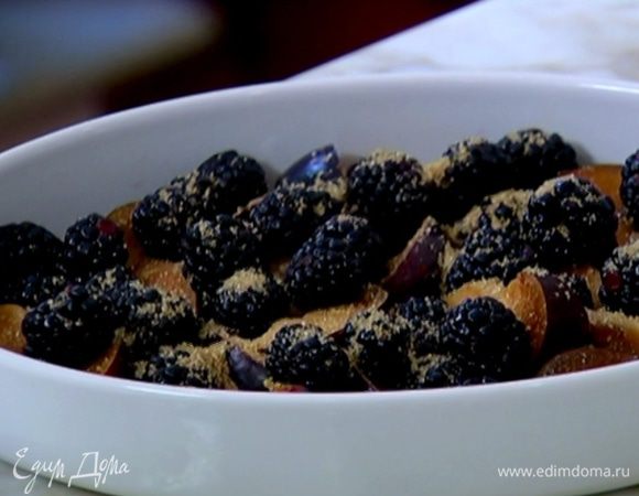 В керамическую форму для выпечки выложить сливы, ежевику, посыпать 1 ст. ложкой сахара и дать постоять.