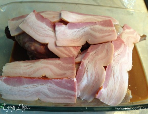 Выложить кролика вместе с маринадом в огнеупорную форму. Накрыть тонко нарезанными кусочками бекона.  Укутать фольгой, можно даже в 2 слоя, чтобы пар при запекании не выходил. Поставить в разогретую до 150 градусов духовку и забыть о нем на 2-2,5 часа...