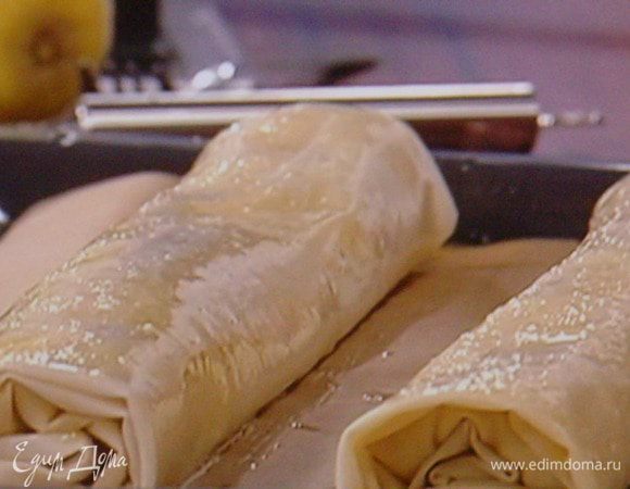  скрутить штрудель в рулет, завернув края во внутрь, чтоб сыр при выпекании не вытек. Перенести аккуратно на противень.  Смазать сверху оставшимся маслом и запечь в разогретой духовке при 180° около 20 мин. до золотистого цвета.