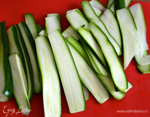 Нарезать цуккини максимально тонкими ломтиками. 