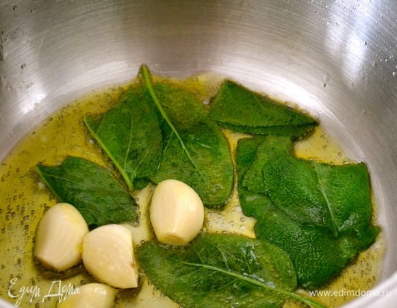 В глубокой широкой кастрюльке поставить обжариваться в оливковом масле целые зубчики чеснока и листья шалфея.  