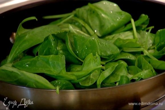 Разогреть в сковороде 2 ст. ложки оливкового масла, добавить чеснок и шпинат и, периодически помешивая, прогревать, пока шпинат не поплывет.