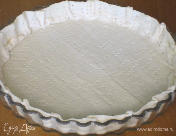 Тесто выложить в форму,наколоть вилкой и посыпать половиной тёртого пармезана.