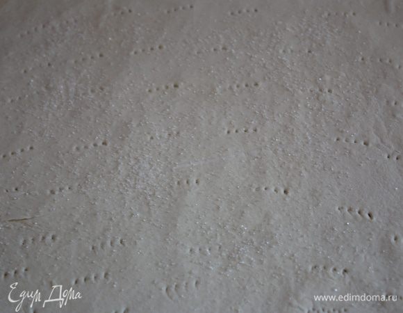 Займемся нашим коржом. Раскатанное тесто с помощью скалки переносим на противень,застеленный пергаментом. Духовку включаем до 230 градусов. Посыпаем тесто сахаром равномерно и ставим в духовку. И сразу снижаем температуру до 190.