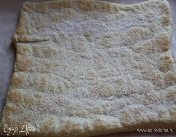 Через 15 минут достаем наш корж. Нам его нужно перевернуть. для этого накрываем его листом пергамента и вторым противнем... и переворачиваем. Посыпаем сахарной пудрой и отправляем в духовку примерно на 10 минут еще. Как только корж станет гладким и блестящим достаем его. 