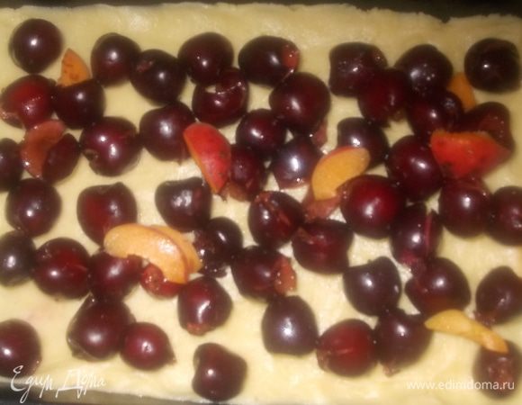 На тесто выложить черешню, присыпать сахаром, я добавила несколько долек абрикосов.