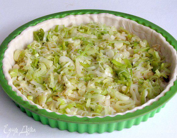 Распределить по поверхности теста подготовленный лук-порей.