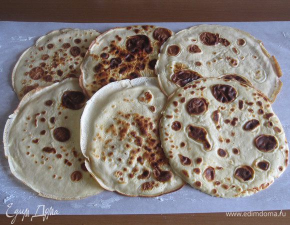 На смазанный сливочным маслом пергамент выложить блинчики внахлест, формируя прямоугольник.