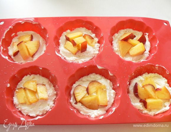 В формы для маффинов выложить по 1-2 ст.л. творожной массы, выложить порезанные нектарины...