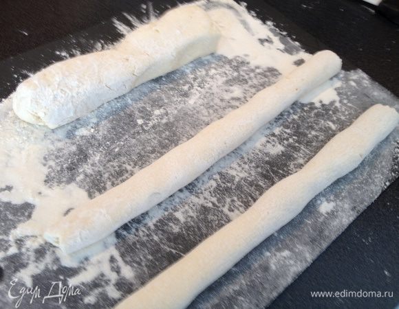 Выложить творожное тесто на доску, посыпанную мукой, начать катать большую колбаску, потом разделить на части и скатать тоненькие колбаски (у меня 4)