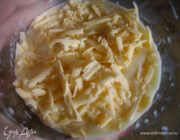 Добавить тертый на крупной терке сыр. И залить этой смесью пирог.