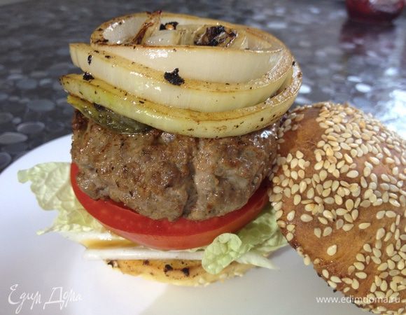 Булочки разрезать пополам, обжарить с внутренней стороны. Кольца лука обжарить, карамелизировать. Собрать гамбургер: булочка, сверху  кетчуп, салат, помидор, котлета, огурчики, колечко лука, крышечка булочки.  Сожмите и откусите!