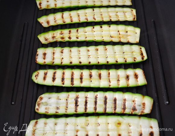 Тонко нарезанный кабачок обжарить на сковороде гриль (без добавления масла!).