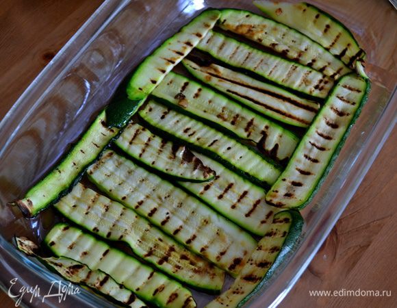 Взять прямоугольную стеклянную форму. Выложить на дно формы первый слой цукини. 