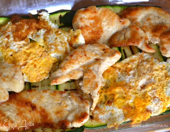 Сверху, чередуя, выложить курицу и два яйца. Затем повторить слой цукини, и снова курицу с оставшимися двумя яйцами.