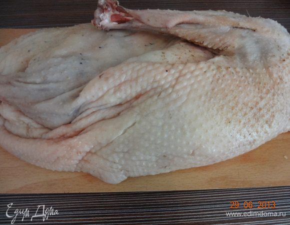 Тушку гуся вымыть (предполагается, что гусь ощипанный и опаленный), обсушить бумажным полотенцем, натереть солью и перцем со стороны кожи и внутренней стороны, хорошо натереть.