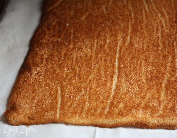 Достаем из духовки, на второй противень или любую термостойкую поверхность кладем пергамент и переворачиваем наш корж. Аккуратно снимаем бумагу, потом это будет сделать сложно, корж начнет ломаться. Даем полностью остыть.