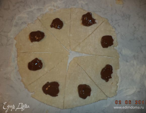 На каждый сегмент выложить по чайной ложке наачинки и свернуть рогалики. Выложить рогалики на противень, смазанный слив. маслом. Поверхность рогаликов смазать взбитым яйцом. 