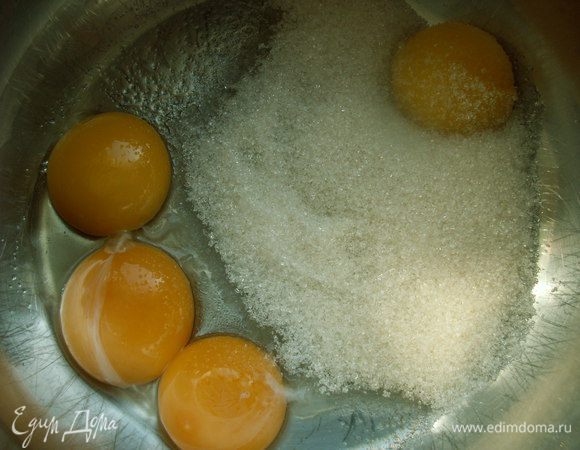  В кастрюле с толстым дном взбиваем желтки с сахаром, добавляем молоко небольшими порциями и ставим смесь на медленный огонь. Готовим, постоянно помешивая до загустения. Снимаем с огня.