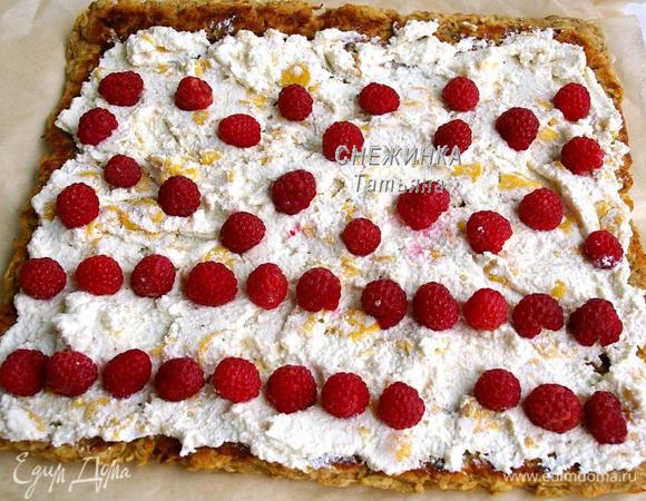 Когда корж остыл, разворачиваем его. Распределяем на пласт начинку. Сверху укладываем ягоды малины (по своему усмотрению).