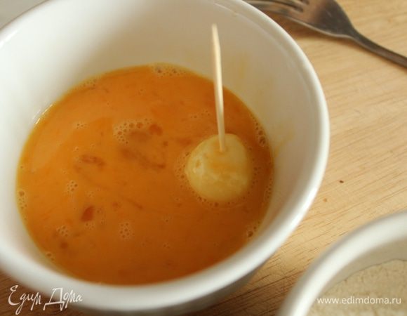 Затем обмакнуть в яйцо. Это удобно делать при помощи деревянной шпажки.