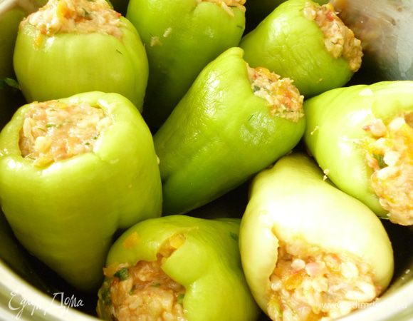 У болгарского перца удалить семена. Наполняем перцы подготовленным фаршем. Выкладываем в посуду, в которой будем готовить