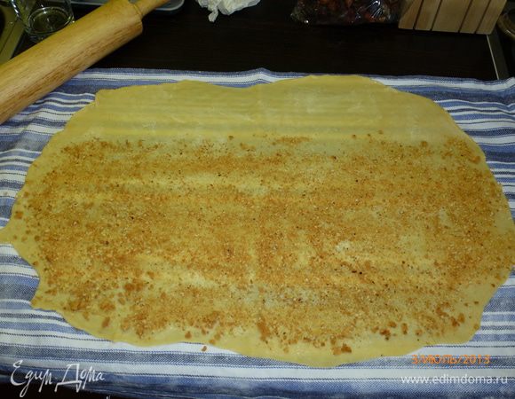 От одной из длинных сторон отступим 7 см, остальное тесто посыпаем растолченным в крошку печеньем. 