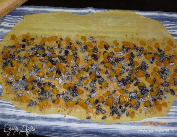 Поверх печенья выкладываем жимолость и абрикосы. Посыпаем сахаром. Оставшееся сливочное масло нарезаем кубиками и выкладываем на начинку. 