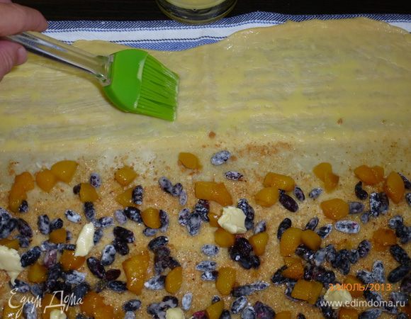 Свободную от начинки часть теста смазываем взбитым с молоком желтком.