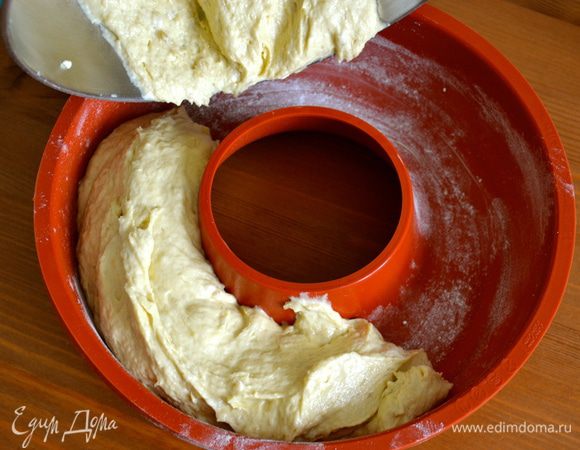 Круглую форму с дыркой (диаметром 26 см) смазать маслом и присыпать мукой. Аккуратно выложить в форму получившееся тесто. 