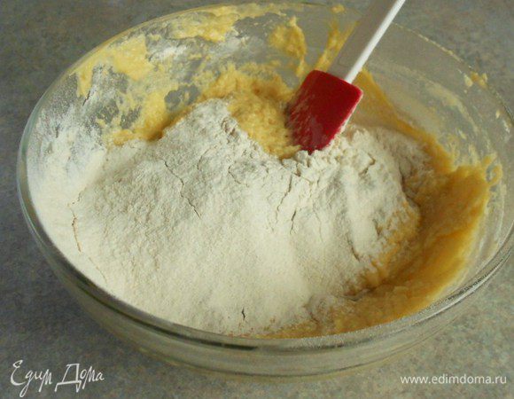  К масляной смеси просеивайте в 3 приёма муку с разрыхлителем, каждый раз добавляя яичную смесь.
 Перемешайте до однородной массы. Если хотите, добавьте молотый миндаль в последнюю очередь. При слишком густом тесте можно добавить чуть-чуть молока.