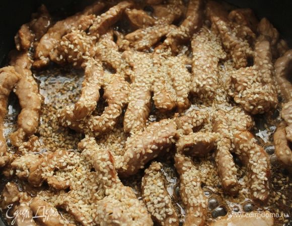 На отдельной сковороде обжарить свинину с добавлением соевого соуса и кунжутного семени.