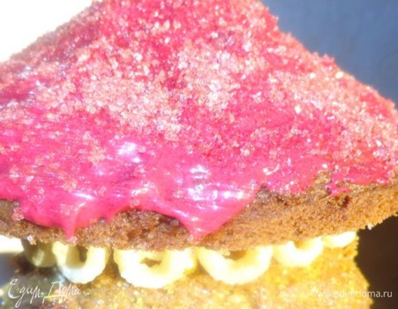 Крышу обмазать красным кремом и обсыпать красной посыпкой. Место стыка между крышей и основой обложить кукурузными штучками, потому что надо будет спрятать выступивший от тяжести крыши крем.Поставить в холодильник, чтобы все как следует скрепилось.