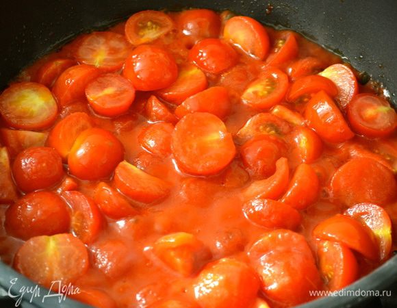 Помидорки-черри помыть и нарезать пополам. В глубокой сковороде разогреть оливковое масло, положить помидорки и томатный соус, посолить и поперчить по вкусу. Тушить на огне около 20 минут, время от времени помешивая.  