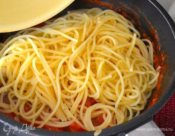 Спагетти отварить в большом количестве соленой воды, согласно указаниям на упаковке. Готовые спагетти слить и выложить в сковороду с помидорным соусом. Как следует перемешать и снять с огня.   