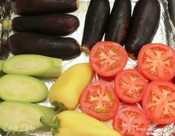 Сегодня я делала небольшую порцию этой икры... У меня 3 баклажана, одна головка чеснока, один кабачок, 3 помидора и 2 перца. Овощи помыть, разрезать пополам (кроме перцев) и выложить на обильно смазанный оливковым маслом противень.