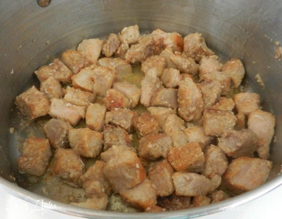 В большой глубокой кастрюле разогреть олив. масло на среднем огне. Мясо, нарезанное кубиками, обвалять в муке, соли и перце и бросить обжариться в кастрюле с разогретым маслом. Обжарить говядину минут 5 (у меня была свинина), выложить на тарелку в сторону.